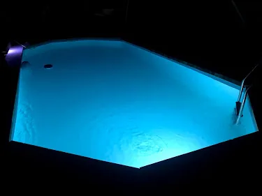 Piscine extérieure de la Villa Charlène entourée de transats, ouverte en saison, avec vue sur les montagnes.