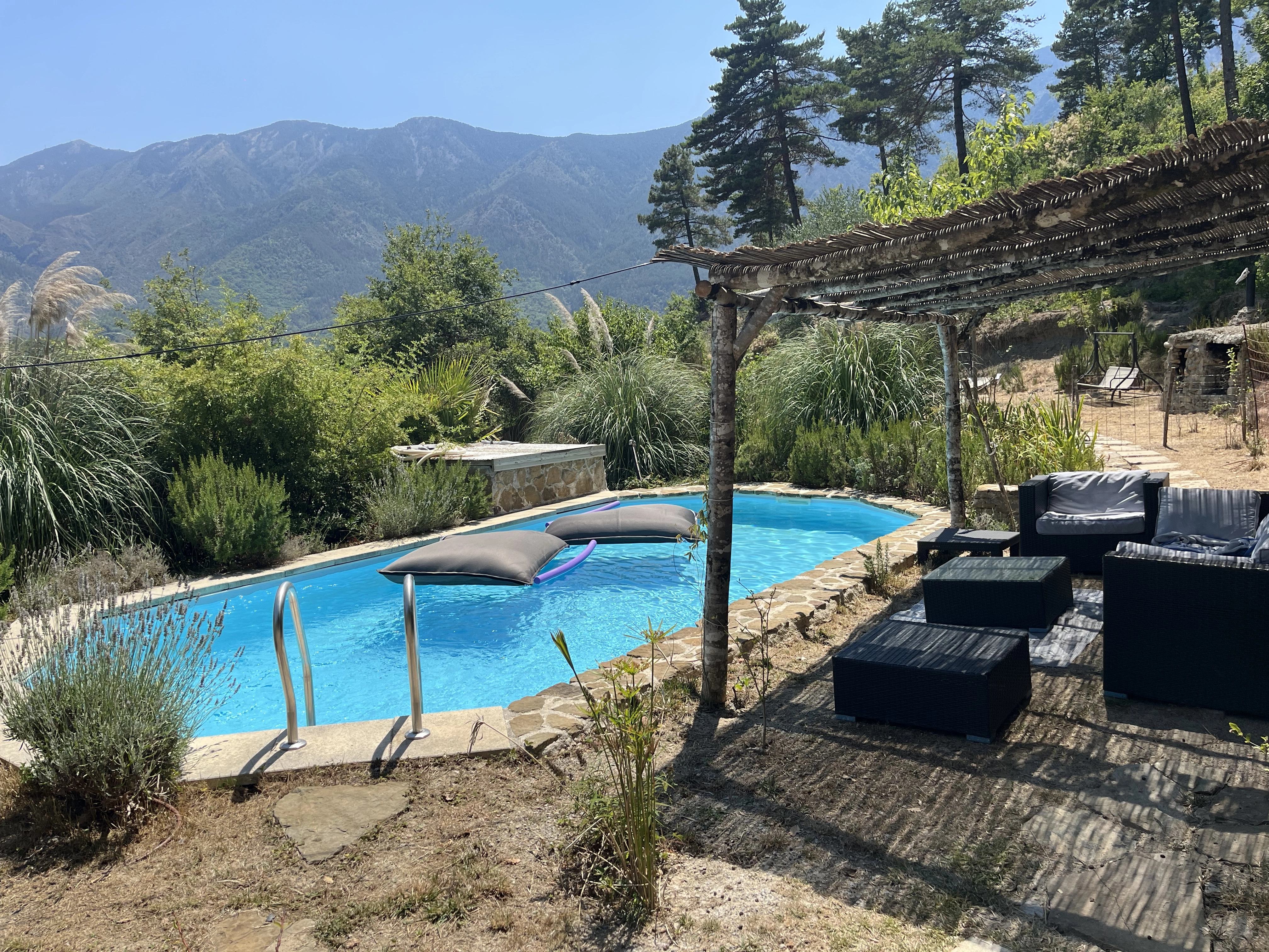 Vue de la piscine à la villa Charlène dans un cadre verdoyant